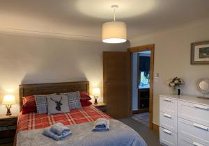 a bedroom with a bed with two towels on it at Ivy Cottage, Aberfeldy - Highland Perthshire in Aberfeldy