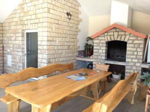 een eetkamer met een houten tafel en een stenen open haard bij Apartment in Rogoznica - Sibenik Riviera 36449 in Rogoznica