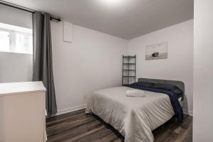 een witte slaapkamer met een bed en een raam bij Two bedrooms in 2 floors apartment - 101 in Montreal