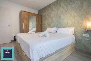 a bedroom with a large bed with white sheets at Playa Verde Las Canteras in Las Palmas de Gran Canaria