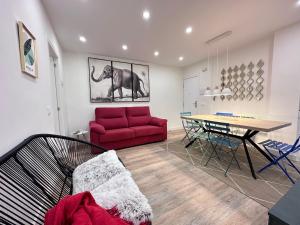 ein Wohnzimmer mit einem roten Sofa und einem Tisch in der Unterkunft La Casita de Tita in Salamanca