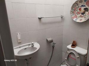 a bathroom with a toilet and a sink at CIDERES HOLIDAY HOME in Majalengka