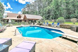 a swimming pool with chairs and a house at Luxury Cabin with Heated Pool, Hot-Tub & Deluxe Outdoors in Morganton