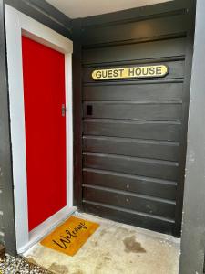 a garage door with a guest house sign on it at Short Stay- ENTIRE GUESTHOUSE! in Halcombe