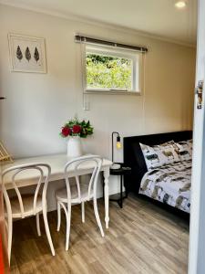 um quarto com uma mesa e duas cadeiras e uma cama em Short Stay- ENTIRE GUESTHOUSE! em Halcombe