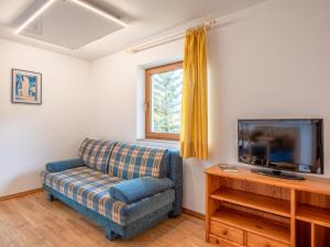 uma sala de estar com um sofá e uma televisão de ecrã plano em Appartement Brixnerwirt I em Brixen im Thale