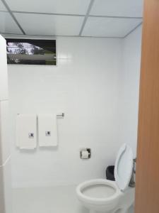 uma casa de banho branca com um WC e uma janela em HOTEL PARQUE VIA em Cidade do México