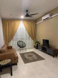 a living room with a couch and a television at ALEENA STAYCATION @ APARTMENT TOK PELAM PANTAI BATU BURUK in Kuala Terengganu