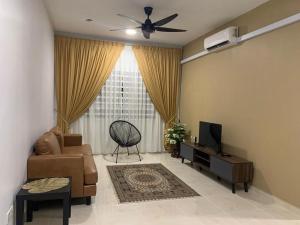 a living room with a couch and a tv at ALEENA STAYCATION @ APARTMENT TOK PELAM PANTAI BATU BURUK in Kuala Terengganu