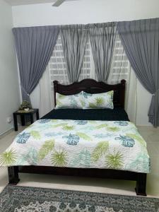 1 dormitorio con cama con edredón en ALEENA STAYCATION @ APARTMENT TOK PELAM PANTAI BATU BURUK en Kuala Terengganu