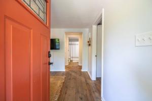 einen Flur mit orangefarbener Tür in einem Zimmer in der Unterkunft Downtown Bungalow Less than 1 Miles to UGA in Athens