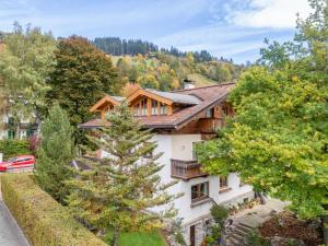 a house in the mountains with a tree at Appartement Brixnerwirt IV in Brixen im Thale