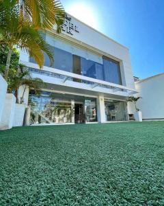 a building with a green lawn in front of it at HOTEL HABANA REAL in Apartadó