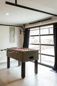 a ping pong table in a room with a window at Greenway Garage with Firepit in Athens