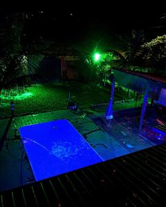 Una foto nocturna de un trampolín con luces azules en Casa de temporada Xerém en Duque de Caxias
