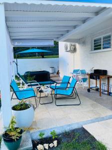 eine Terrasse mit Stühlen, einem Tisch und einem Klavier in der Unterkunft Le Cocon de l'Oranger in Le Moule