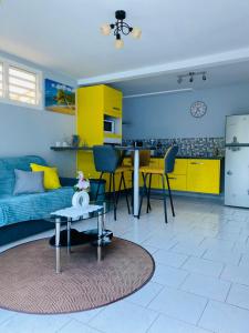 ein Wohnzimmer mit einem Sofa und einem Tisch in der Unterkunft Le Cocon de l'Oranger in Le Moule