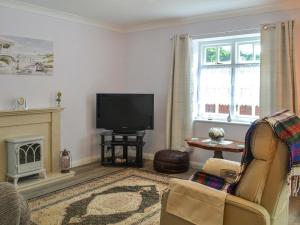uma sala de estar com lareira e televisão em The Stables em Hedon