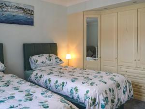 a bedroom with two beds and a mirror at The Stables in Hedon