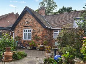 a brick house with potted plants in front of it at The Stables in Hedon