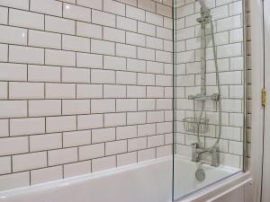 Worle的住宿－Coopers Townhouse，白色瓷砖浴室设有淋浴和浴缸。