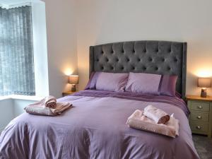 sypialnia z dużym łóżkiem z dwoma ręcznikami w obiekcie Trinity Avenue Cottage w mieście Bridlington