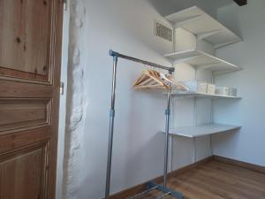 Zimmer mit einem Schrank mit Regalen und einem Besen in der Unterkunft Le Refuge de Normandie avec Spa et Cheminée in Mesnières-en-Bray