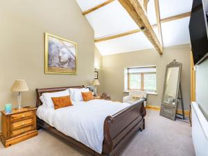 a bedroom with a large bed and a tv at Chestnut Barn in Wold Newton