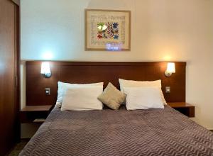 uma cama num quarto de hotel com duas almofadas em Hermoso departamento en San Miguel De Allende em San Miguel de Allende