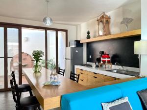 uma cozinha com uma mesa de madeira e um sofá azul em Hermoso departamento en San Miguel De Allende em San Miguel de Allende