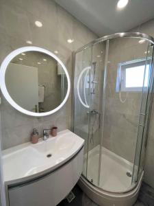 ein Bad mit einer Dusche, einem Waschbecken und einem Spiegel in der Unterkunft Apartment in Primosten - Sibenik Riviera 35574 in Primošten