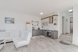 ein Wohnzimmer mit einer weißen Couch und einer Küche in der Unterkunft Apartments by the sea Kneza, Korcula - 21863 in Pupnat
