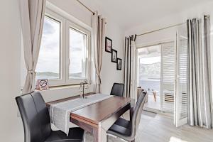 ein Esszimmer mit Tisch und Stühlen und einem Fenster in der Unterkunft Apartments by the sea Kneza, Korcula - 21863 in Pupnat