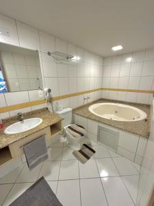 uma casa de banho com uma banheira, um WC e um lavatório. em Saint Sebastian Flat 716 - Com Hidro! até 3 pessoas, Duplex, no centro em Jaraguá do Sul