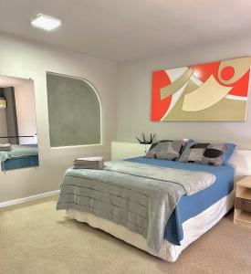 1 dormitorio con 1 cama y una pintura en la pared en Saint Sebastian Flat 716 - Com Hidro! até 3 pessoas, Duplex, no centro en Jaraguá do Sul