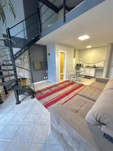 uma grande sala de estar com um sofá e uma escada em Saint Sebastian Flat 716 - Com Hidro! até 3 pessoas, Duplex, no centro em Jaraguá do Sul