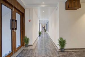 an empty hallway with potted plants in a building at OYO Collection O Hotel Infini Palace in Surat