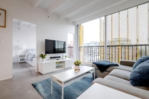 uma sala de estar com um sofá e uma televisão em Modern, Bright & Beautiful, 1 Bedroom Downtown Apt with Rooftop Patio em Vancouver