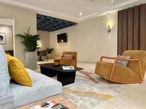 a living room with a couch and chairs and a table at Hôtel AL AFIFA in Dakar