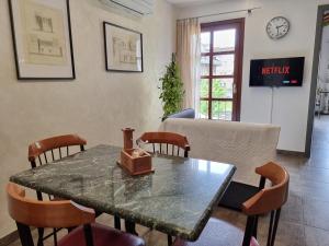 a living room with a table and chairs and a tv at Maison Bodroz appartamento Charme in Aosta