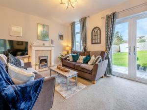 sala de estar con sofá y chimenea en Driftwood, en Teignmouth