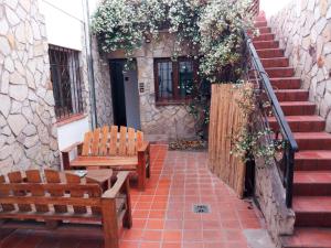 2 bancos de madera sentados en un patio con escaleras en Casa Montaña en Salta