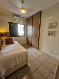 a bedroom with a large bed and a window at Flat Capitânia Varam 143 Pitangueiras in Guarujá