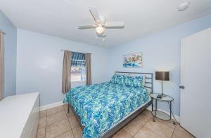 1 dormitorio con 1 cama y ventilador de techo en Blue Water Beachside Villa 1 en Clearwater Beach