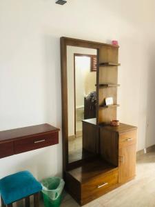specchio e cassettiera in legno in una stanza di Ocean Pearl Cottage ad Ahungalla