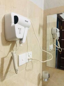 a hair dryer on a wall in a bathroom at Ocean Pearl Cottage in Ahungalla