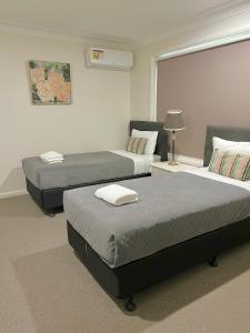 a room with two beds and a window at North Ryde Guesthouse in Sydney