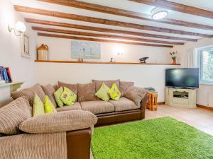 a living room with a couch and a flat screen tv at Clover Cottage- Uk45595 in Verwick