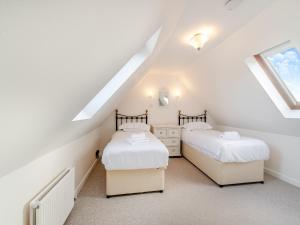 two beds in a attic bedroom with white walls at Clover Cottage- Uk45595 in Verwick