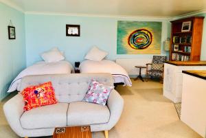 sala de estar con sofá y 2 camas en Butterfield Beach Studio Car petrol and breakfast provisions included, en Half-moon Bay